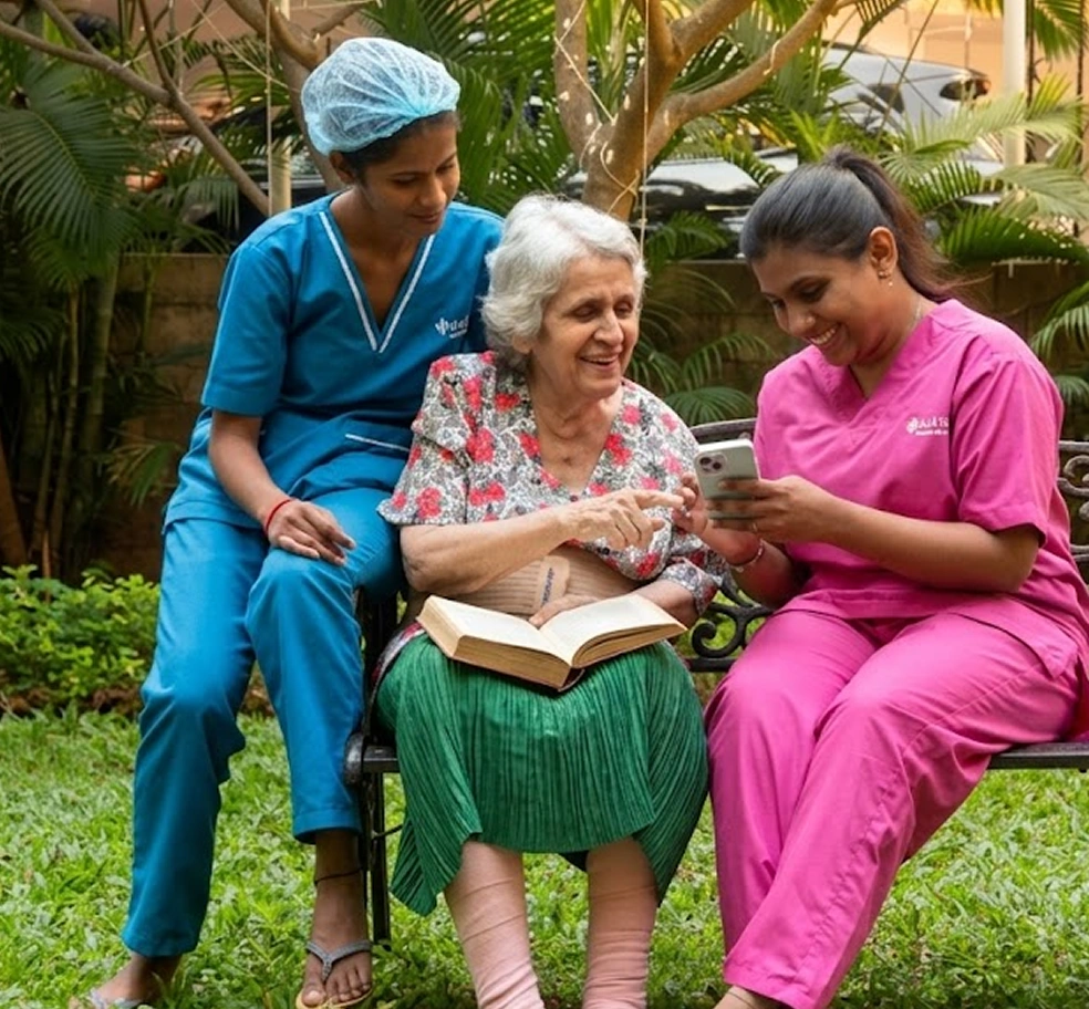 Caregivers and elderly women sitting together in a garden looking at a book